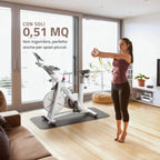 Donna che si allena in casa davanti a una bike indoor Yesoul S3 posizionata in un soggiorno luminoso, con ingombro ridotto adatto anche a spazi piccoli